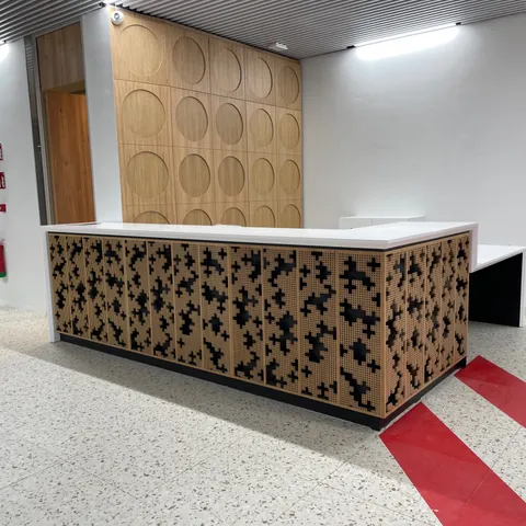Recepción con mostrador de celosía de madera y panel decorativo circular