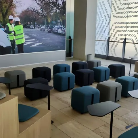 Zona de descanso con pufs y pantalla corporativa