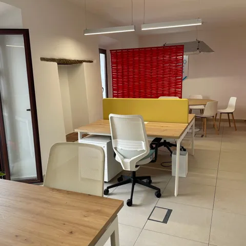 Puestos de coworking junto a panel decorativo rojo