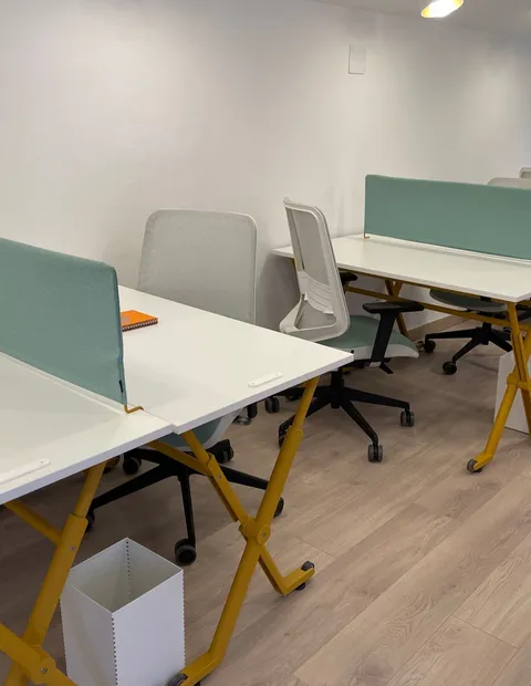 Mesas altas de coworking con mampara verde