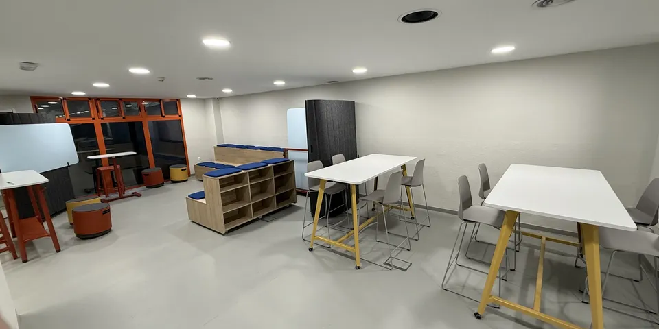 Sala de trabajo con mesas técnicas y almacenaje abierto