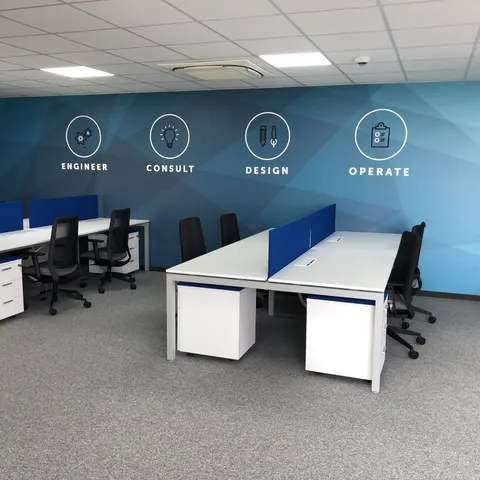Mesas de trabajo de pie con taquillas al fondo