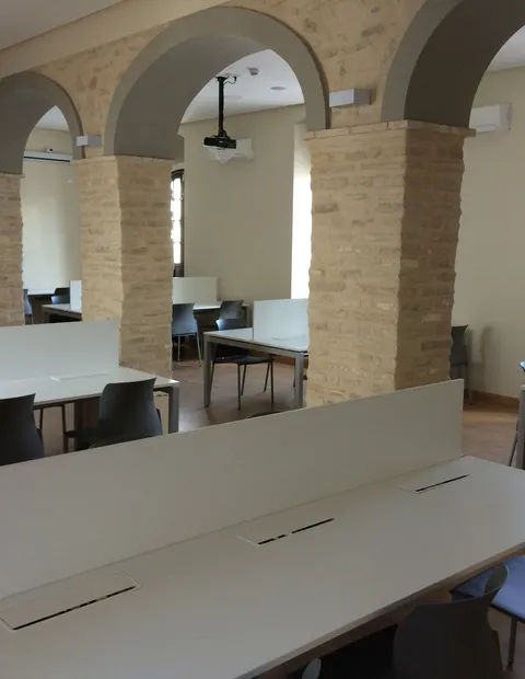 Puestos de coworking con mamparas azules y pared corporativa