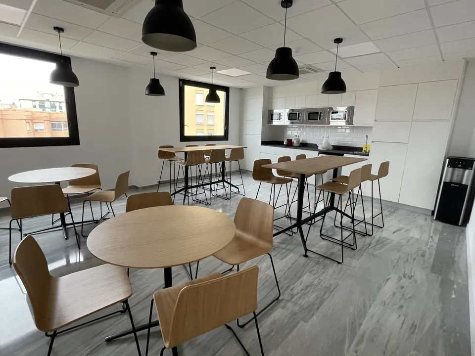 Mesas compartidas de coworking bajo arcos de piedra