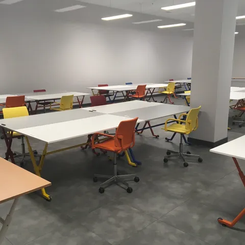Mesas de formación con estructura naranja y taburetes