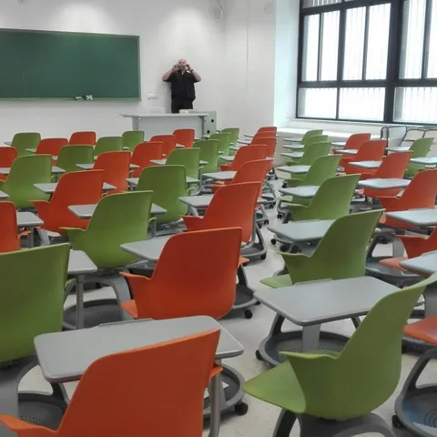 Aula magna con sillas de pala en filas