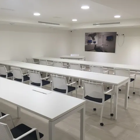 Aula de formación con mesas en filas orientadas a la pizarra