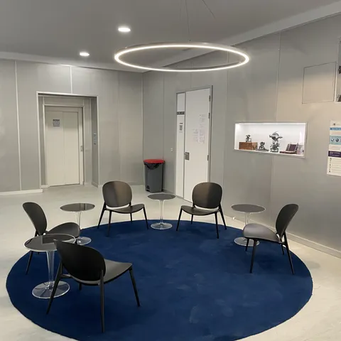 Rincón de lectura con alfombra circular y sillas ligeras