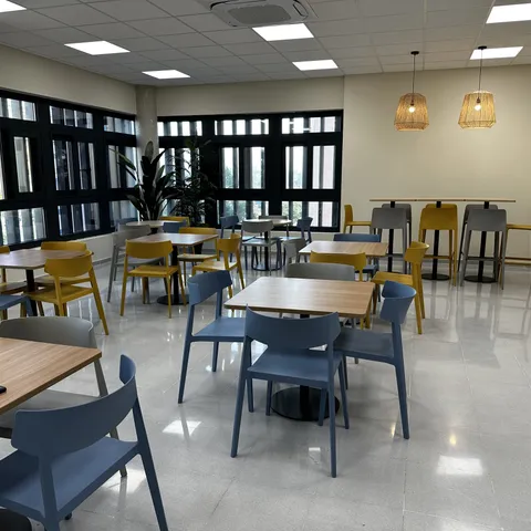 Sala de restauración con mesas altas y taburetes