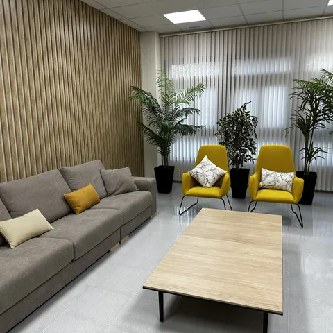 Sala de espera con sofá y sillones en mostaza