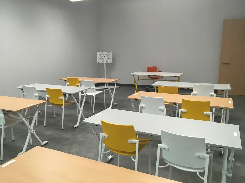 Sala polivalente con mesas y sillas móviles