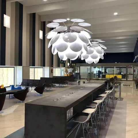 Barra alta con taburetes y lámpara decorativa