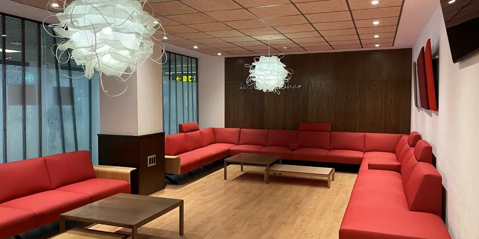 Área de espera con banco tapizado en rojo